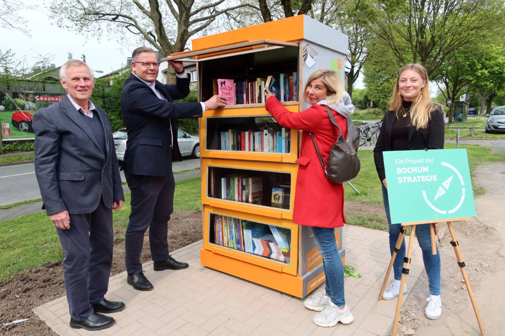Buecherschrank-Werne Zwei Männer und zwei Frauen präsentieren einen Bücherschrank