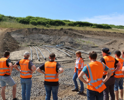 oberflaecehnabdichtung eine Menschengruppe schaut sich die Fortschritte auf einer Baustelle an